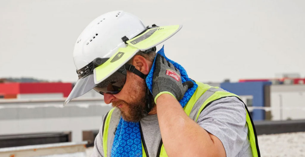Vue large d'un chantier de construction français sous un soleil d'été intense avec grues et structures métalliques